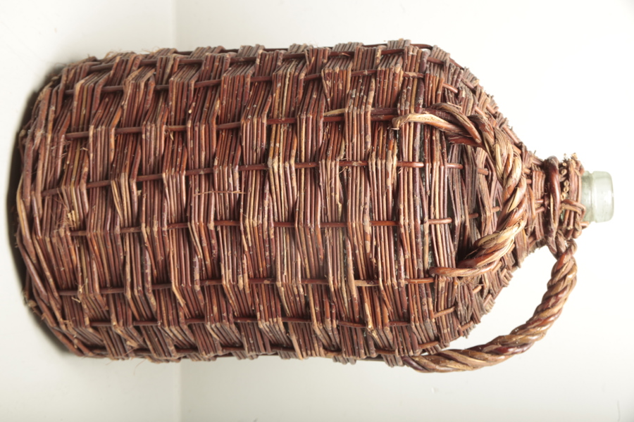 Damejeanne i flätad korg