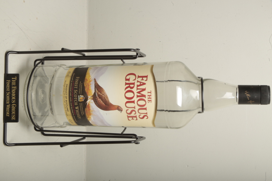 Whiskyflaska i ställning, Text: "The Famous Grouse" 4L