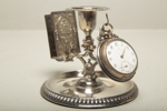 Klockställ i metall med fickur i silver, 1900-tal 