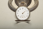 Klockställ i metall med fickur i silver, 1900-tal 